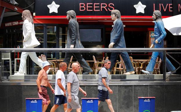 Turistas caminan frente a un 'pub' de Benidorm/EFE/Manuel Lorenzo